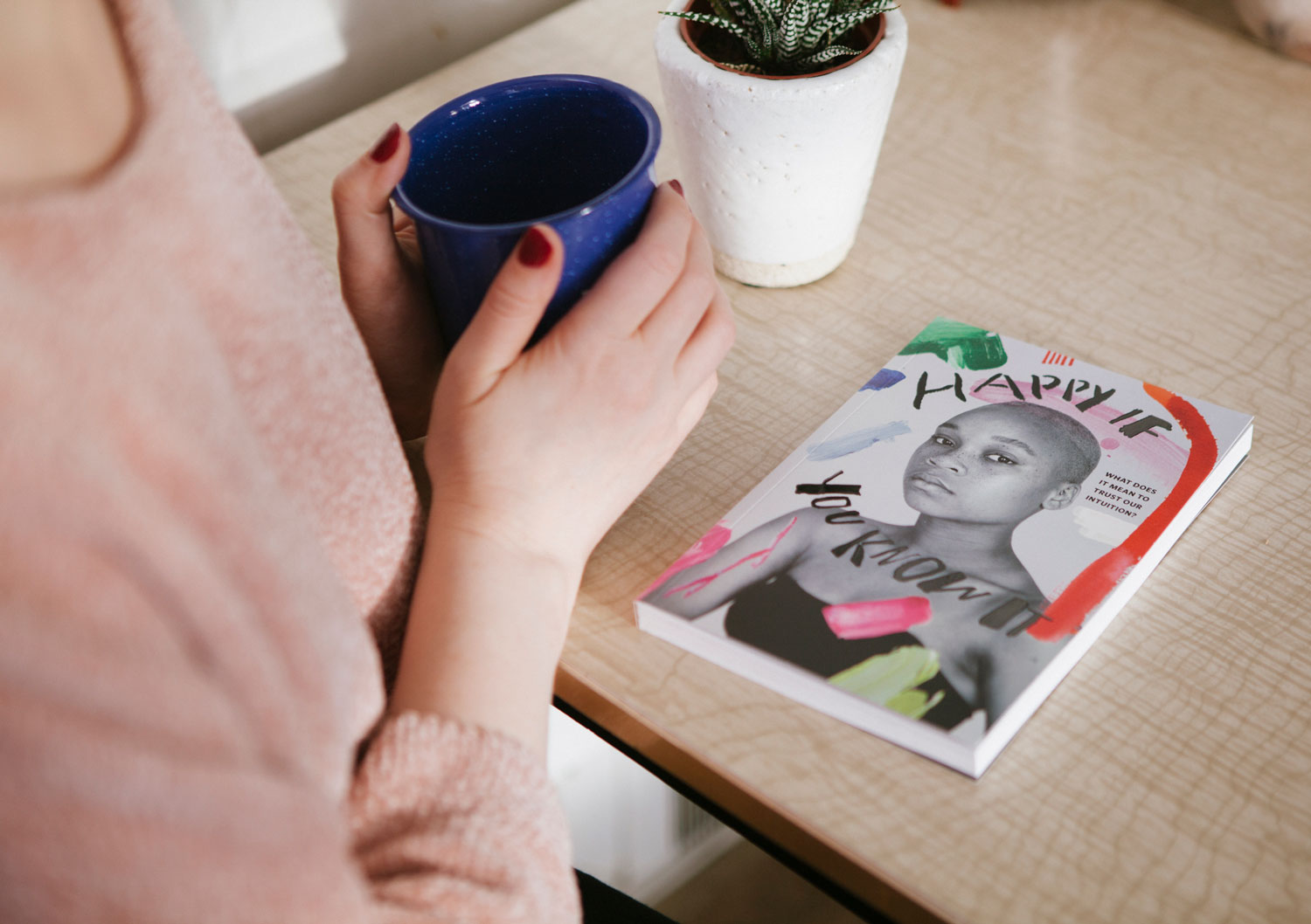 Person sitting and enjoying a coffee while reading Happy If You Know It by Jen Spinner