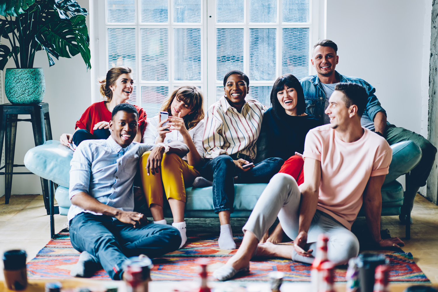 shutterstock_1774977266-sm01 A group of diverse friends sitting on a couch, laughing together.